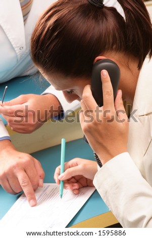 Medical secretary calling on the phone - doctor in the background