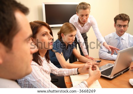 Group of five business people working together on project - three men and two women