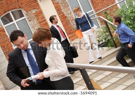 Angled shot of five people dressed in business and casual business attire, in various activities.