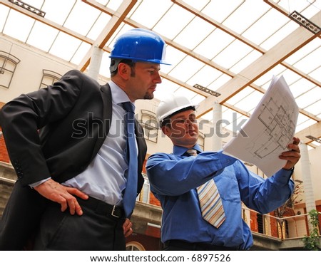 architect and supervisor Reviewing Blueprints
