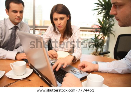 Group of business people sitting at the table, working with laptop, 2 men and 1 woman