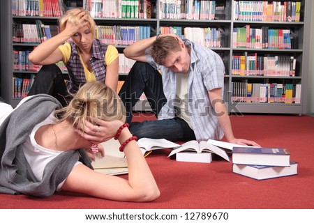 group of students reviewing books in the library