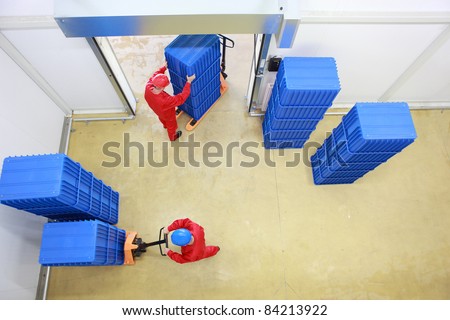 Aerial view of two workers loading plastic boxes  in small warehouse