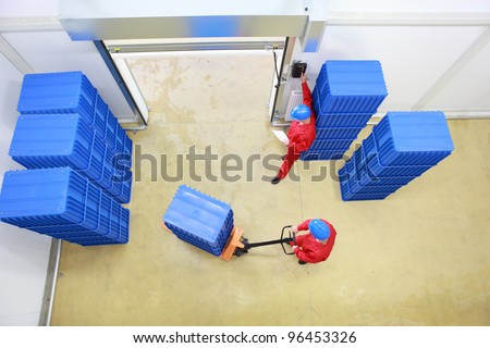 two workers preparing goods delivery in a small company warehouse - overhead vie