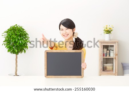 Japanese woman thumbs up gesture with bulletin board