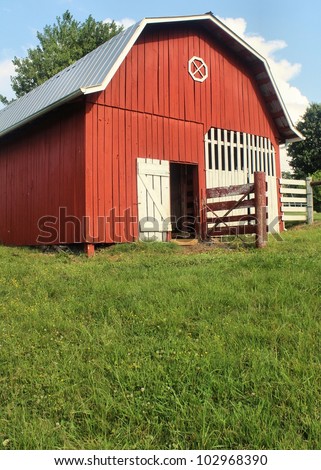 red barn with white trim and green pasture