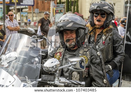 BARCELONA, SPAIN - JULY 08: Unidentified persons with typical biker jacket a Harley Davidson motorbike at an exhibition during BARCELONA HARLEY DAYS 2012, on July 08, 2012, Barcelona, Spain.