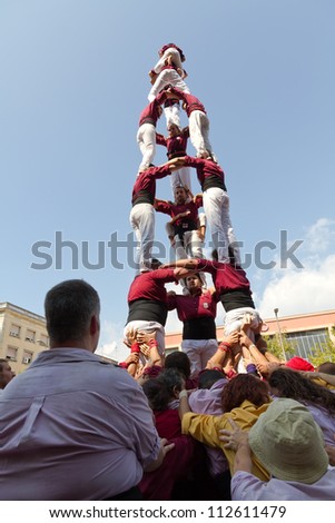BARCELONA - SEPTEMBER 11: Some unidentified people called Castellers do a Castell or Human Tower, typical tradition in Catalonia, on September 11, 2012 in Barcelona, Spain.