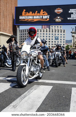 BARCELONA, SPAIN - JULY 05, 2014: Unidentified persons with a Harley Davidson motorbike at an exhibition during BARCELONA HARLEY DAYS 2014, The event brought together over 12,000 motorcycles.
