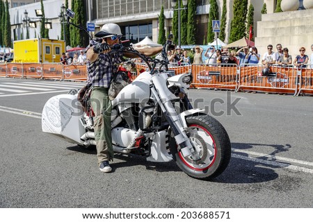 BARCELONA, SPAIN - JULY 05, 2014: Unidentified person with a Harley Davidson motorbike at an exhibition during BARCELONA HARLEY DAYS 2014, The event brought together over 12,000 motorcycles.