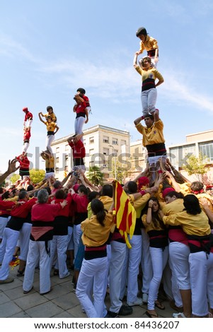 BARCELONA - SEPTEMBER 11: Some unidentified people called Castellers do a Castell or Human Tower, typical tradition in Catalonia, on September 11, 2011 in Barcelona, Spain.