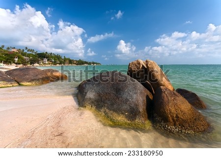 Big round stones on the coast of the turquoise sea.