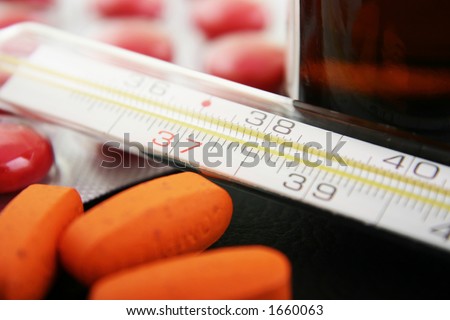 Thermometer with medication. Focus on thermometer