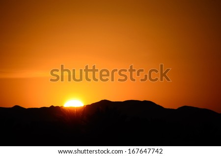 beautiful sunset with black mountain and bright sun