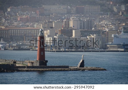 lighthouse with stone statue in the harbor by the sea
