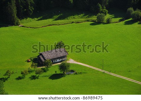 house in nature with plenty of green grass and forest