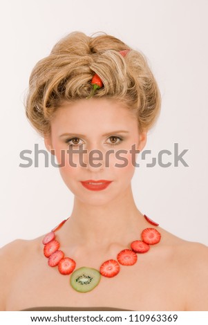 Attractive blonde young woman with strawberry-kiwi-chain /Hot blonde with strawberry / kiwi chain