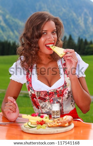 Bavarian girl in eating cheese / Enjoy your meal