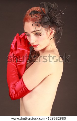 Portrait of a model with an elaborate hairstyle with ribbon in her hair and red gloves /Hair variant