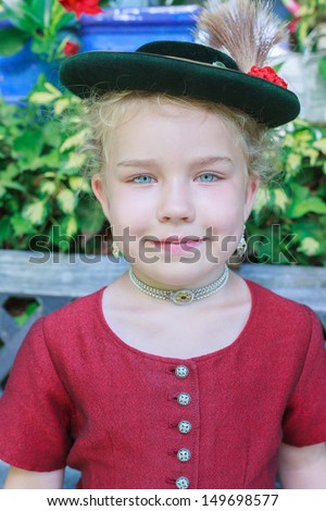 Portrait of a little girl with hat in traditional Bavarian dirndl / Portrait of a young Bavarian girl with hat