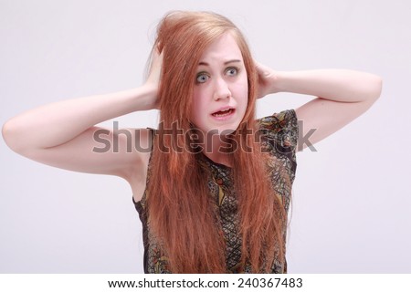 Female model with hands on both sides of her head looking frustrated. / Female model looking frustrated