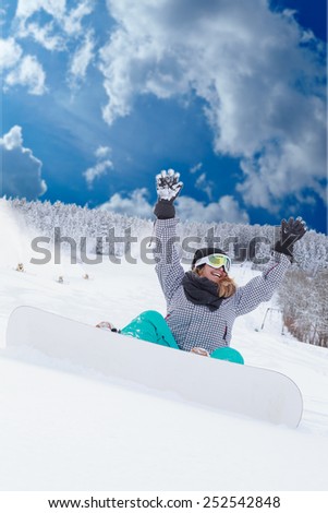 Young blonde chubby girl Oversizes sitting with your snowboard in the snow and looking forward with hands raised /Young girl Oversizes sitting with your snowboard in the snow and would be
