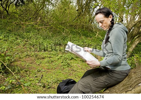 woman hiker reading map in woodland