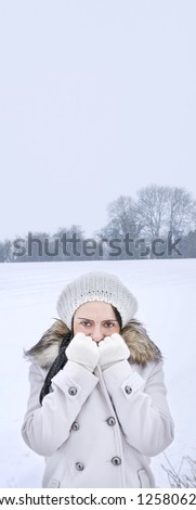 woman feeling cold in field covered in snow with copy space vertical banner