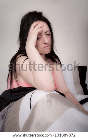 woman thinking in bed looking sad or bored portrait