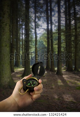 lost man holding compass in middle of forest with many paths to choose from