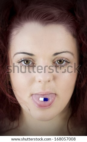 teenage girl with pill on her tongue taking medication portrait