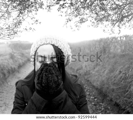 woman cold standing on country lane black and white