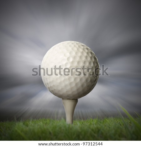closeup of golf ball on golf tee with stormy fast moving sky background