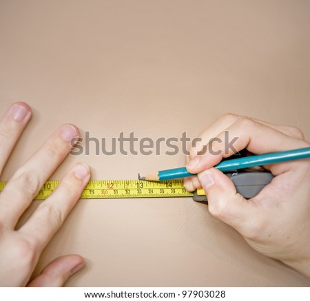 measuring with tape measure and marking wall with pencil