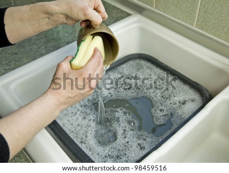 woman cleaning mug with scouring pad
