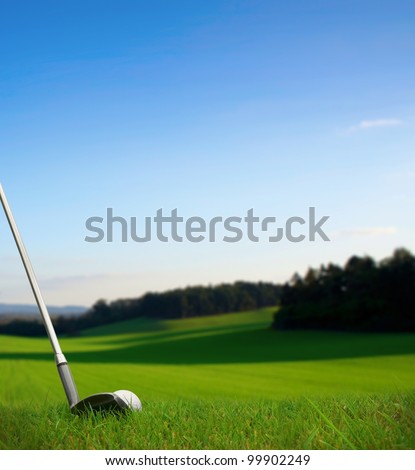 hitting golf ball with club along fairway towards green