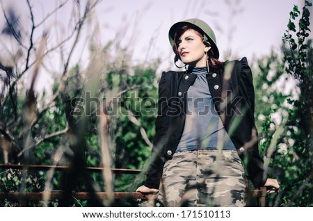Attractive young girl in army clothes outdoors
