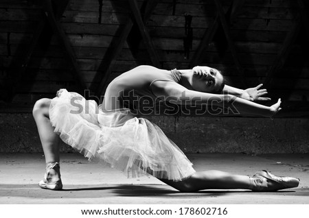 Ballerina in white tutu posing. Dark background and dynamic light.