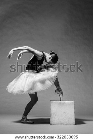 Graceful ballerina in white tutu standing on toes. Studio shot, grayscale image.