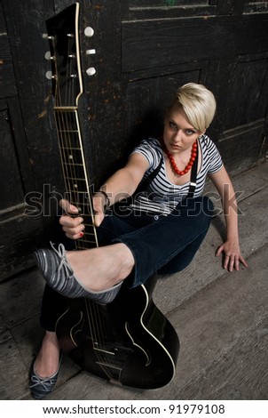 Young attractive girl posing with acoustic guitar, dynamic composition.