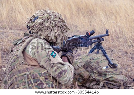 GALATI, ROMANIA - OCTOBER 8: English soldier with machine gun M240 on the firing line in Romanian military polygon in the exercise Smardan Danube Express 14 on Galati, Romania, 8 october 2014.