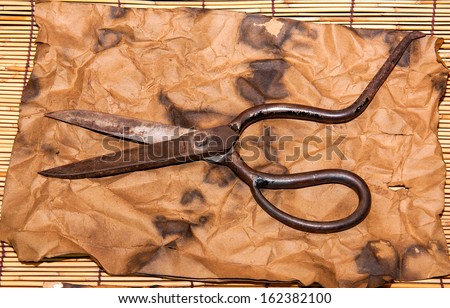 Scissors for cutting leather on  old paper background