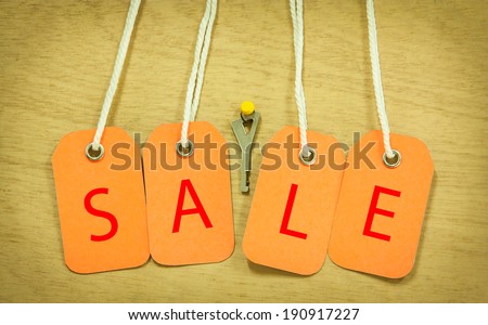 House Key with Sale tag  on a background of plywood.