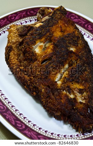 Fried fish dish cooked in oil with a food order.