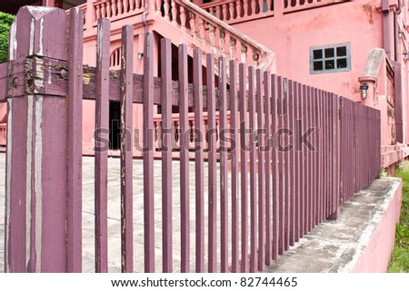Wooden fence. Fence of the house is painted with pink