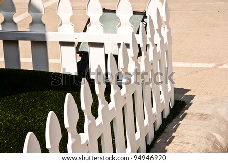 White fence. A low fence separates the small garden.