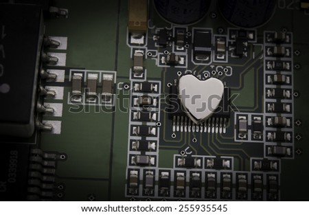 A concept photograph to show liveliness of electronic technology with a metal heart attached to an electronic circuit.