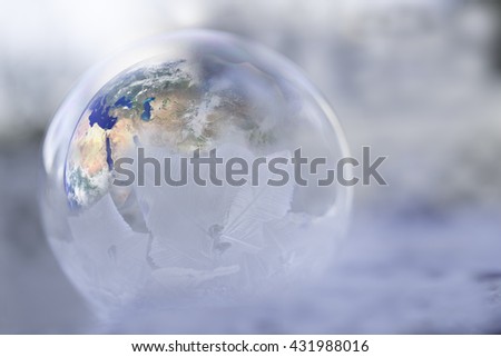 The earth inside a half frozen globe showing impact of global warming in the north and cooling on the south.