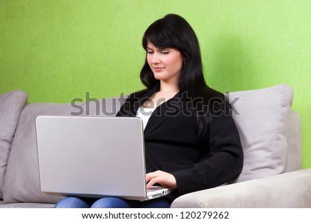 Beautiful business woman on sofa using white laptop
