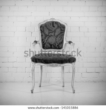Vintage chair against a brick wall. Black and white